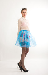 Full length portrait of a beautiful sexy slim model in blue skirt and white blouse transparent, in stockings and garters