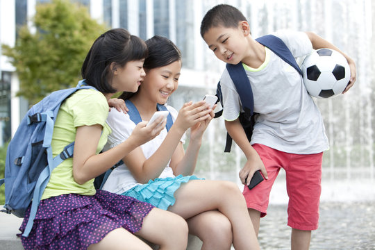 Happy school children and smart phones