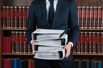 Lawyer Carrying Stack Of Ring Binders