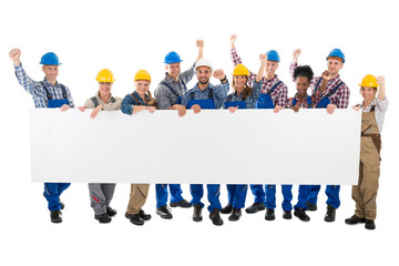Happy Carpenters With Arms Raised Holding Blank Billboard