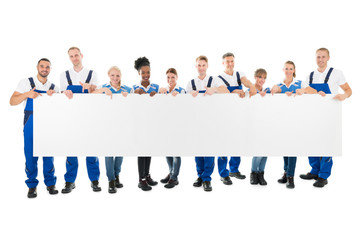 Happy Multiethnic Cleaners Holding Blank Billboard