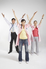 Nurses And Doctor Stretching With Arms Raised