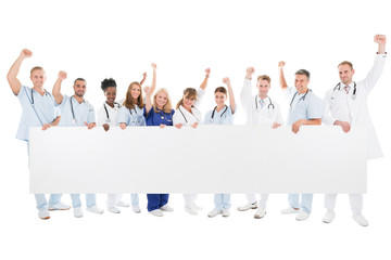 Happy Medical Team With Arms Raised Holding Blank Billboard