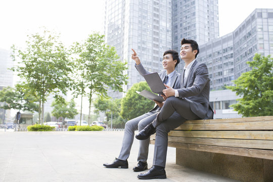 Young business person working with laptop outdoors