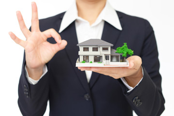 住宅模型を持つ女性