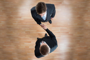 Businessmen Shaking Hands In Office