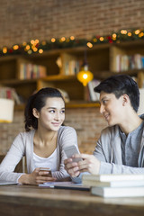 Young couple using smart phone in cafe