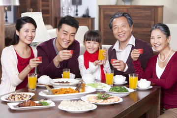 Family toasting at dinner table during Chinese New Year