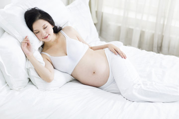Obraz na płótnie Canvas Pregnant woman lying in bed
