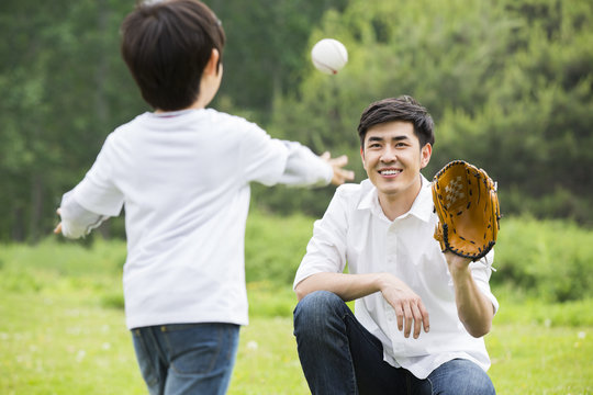 Father and son playing baseball outdoors