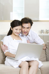 Young couple using a laptop at home