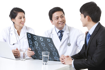 Fototapeta premium Professional doctors checking X-ray image with young man