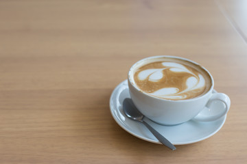 Hot art Latte Coffee in a cup on wooden table