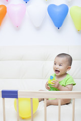 Chinese baby boy playing on a sofa