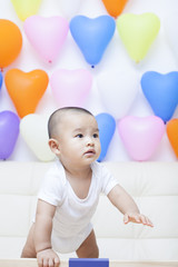 Fototapeta na wymiar Chinese baby boy and colorful balloons