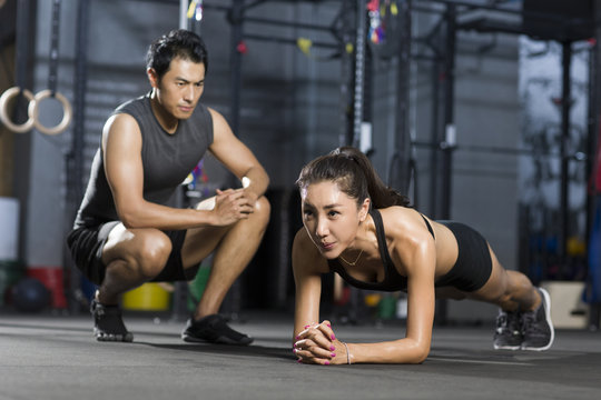 Young woman working with trainer in gym