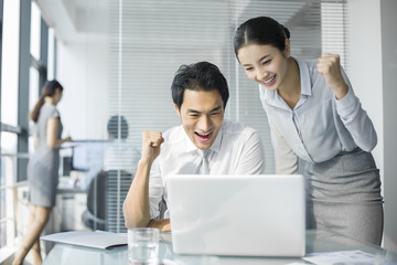 Fototapeta premium Young businesswoman and businessman talking in office