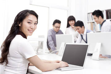 Female office worker using laptop in studio