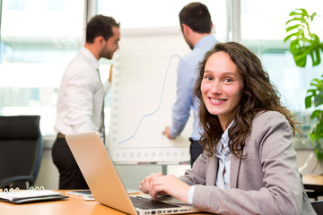 Fototapeta premium Young attractive businesswoman working at the office with associ