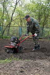 Man working in the garden preparing ground cultivator