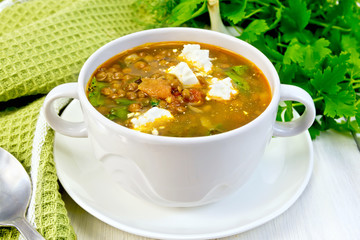 Soup lentil with spinach and cheese on board