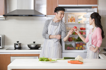 Happy young couple preparing meal