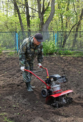 Man working in the garden preparing ground cultivator