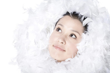 Feathers surrounding the face of young woman