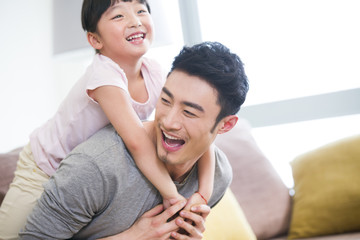 Fototapeta premium Happy father carrying daughter on back