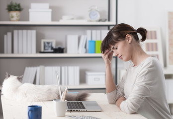 Obraz na płótnie Canvas Woman with headache sitting at desk
