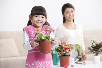 Fototapeta na wymiar Happy mother and daughter with potted plants