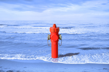 A hydrant at the seaside. Plenty of water: concept image
