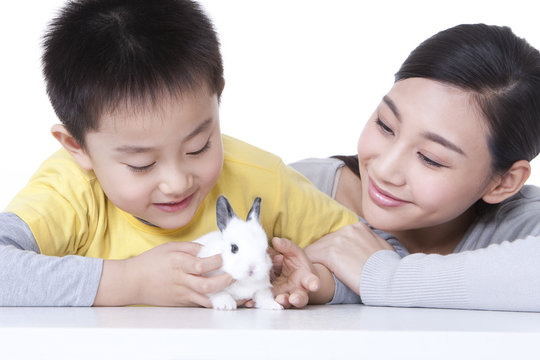 Mother and son playing with rabbit