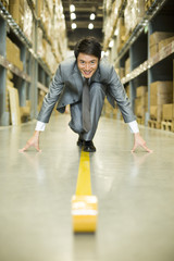 Fototapeta premium Confident businessman ready to run in warehouse