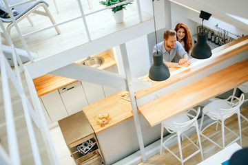 Beautiful couple in well designed kitchen
