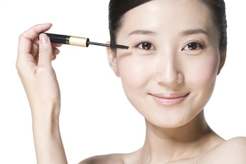 Beauty shot of a young woman applying mascara