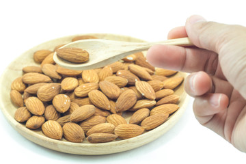 Hand on spoon of almond isolated on white background