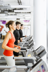 Fototapeta premium Group of young people using treadmills in a gym