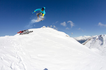 Flying snowboarder on mountains. Extreme sport.