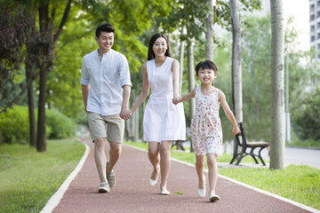 Happy young family walking in park