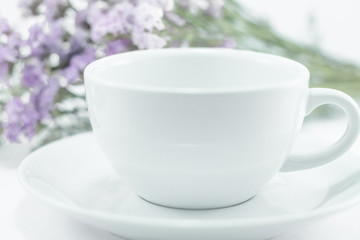 Obraz na płótnie Canvas White mug cup and static flower