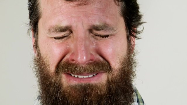 Extreme close up of hipster crying against neutral background