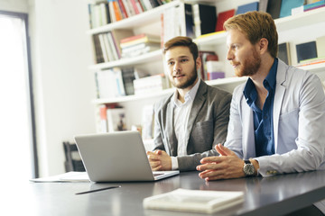 Young businessmen sitting at desk
