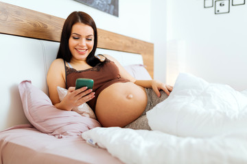 Obraz na płótnie Canvas Beautiful pregnant woman using phone