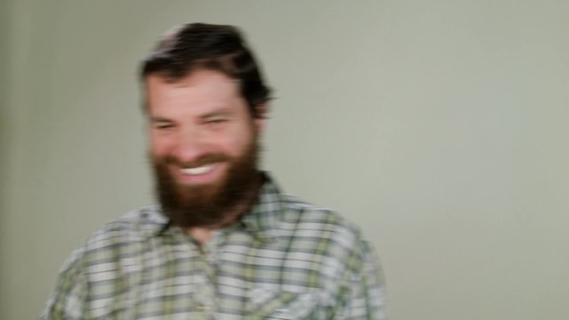 Hipster man says hello in camera on neutral background