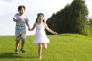 Children holding hands and running outdoors