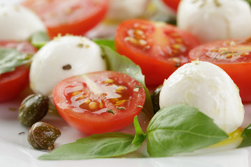 caprese salad with mini mozzarella balls, tomatoes and capers
