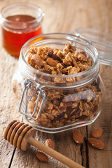 homemade healthy granola in glass jar and honey