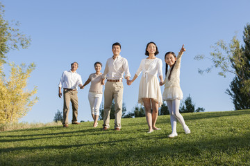 Happy family holding hands looking at view in a park