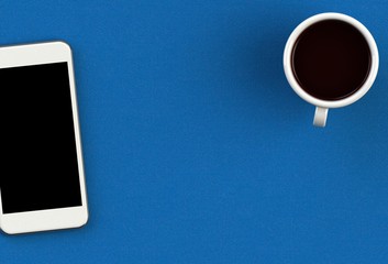 Coffee cup with smart phone on blue fabric table